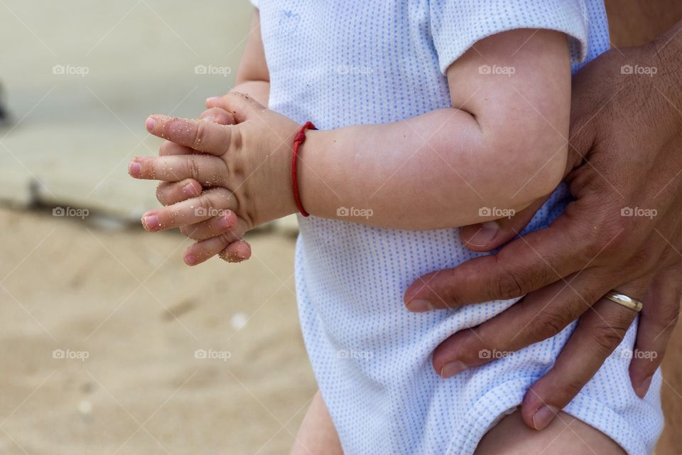 Father's hands supporting the baby