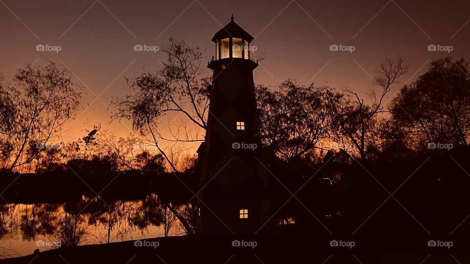 Very Beautiful Silhouetted scene with Lighthouse presence backlit reflections on lakebed. 