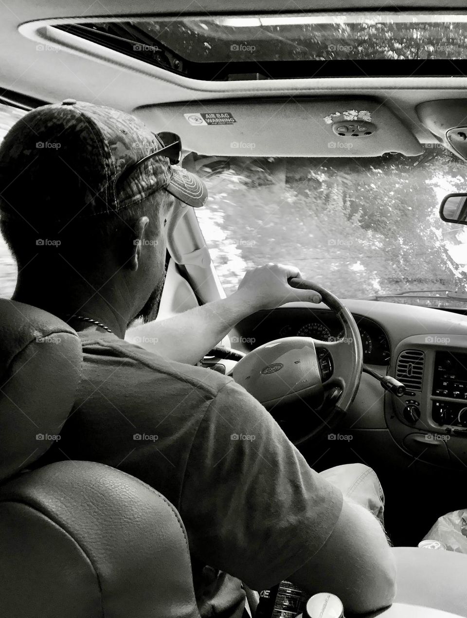 Black and white photo of a man driving his car