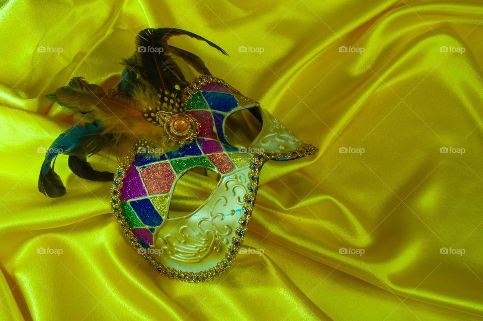 Venetian carnival mask on yellow satin