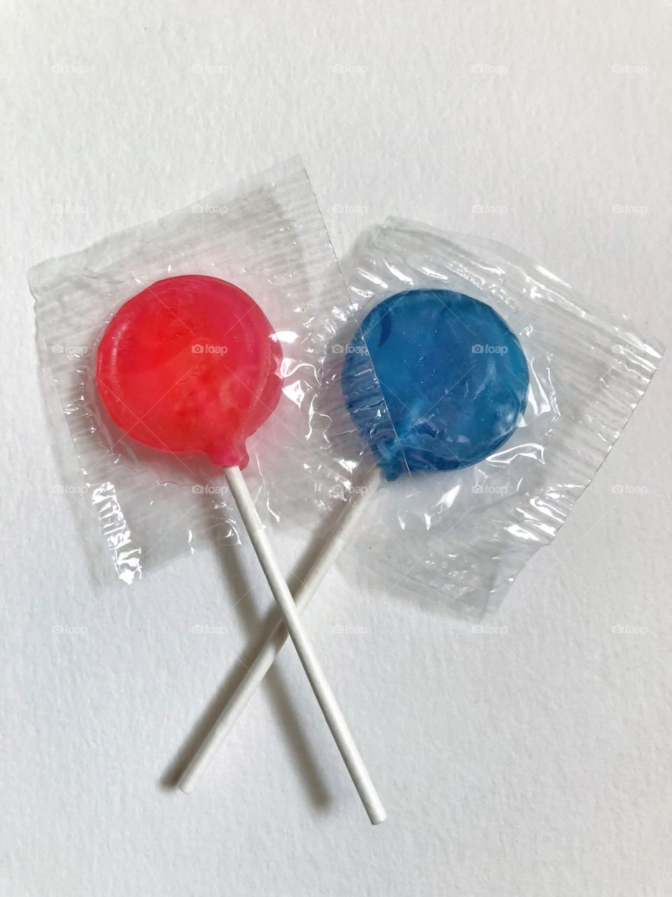 Pink and blue lollipops on white