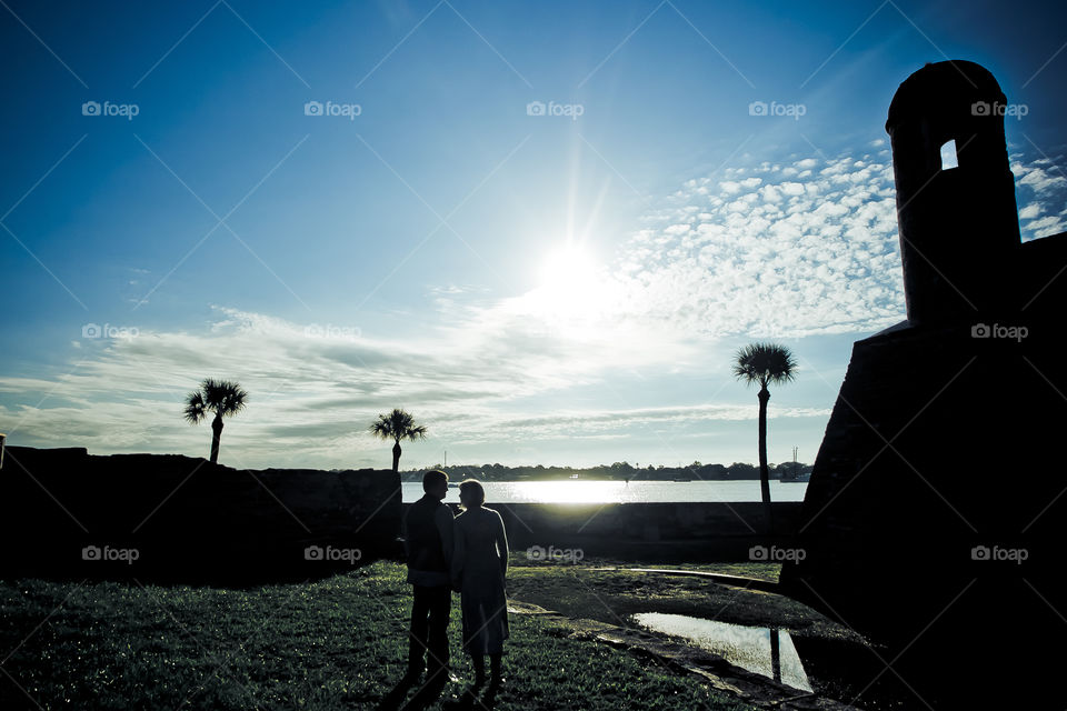 St Augustine; couple under a blue sky by a castle