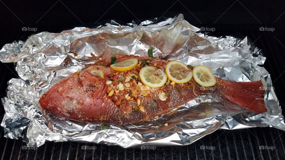 whole fish on grill with lemon