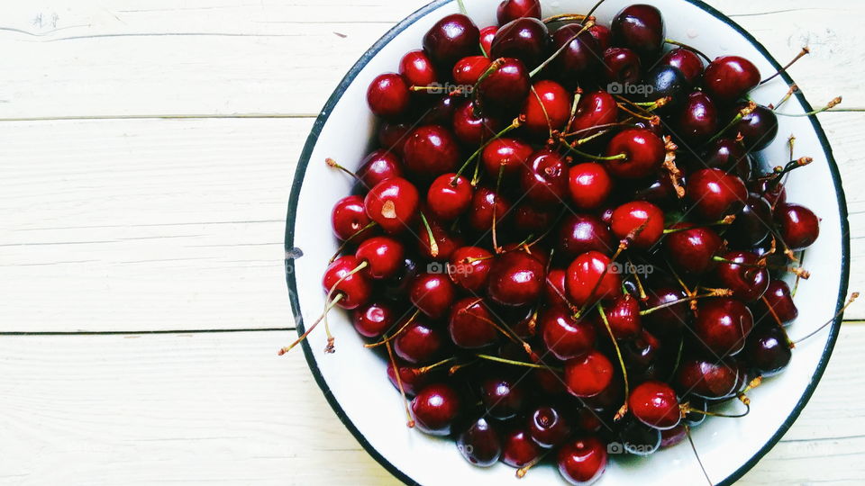 cherries in a bowl on a white background