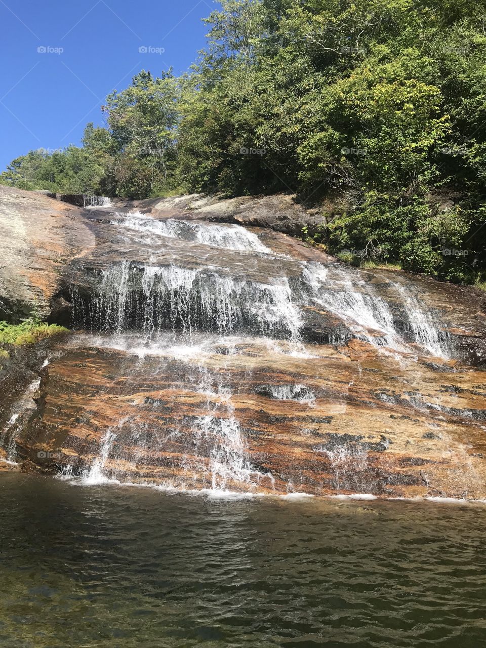 The sedimentary rock seen behind the water of Lower Falls at Graveyard Fields is stunning. The colors pop as the water peacefully cascades down. 