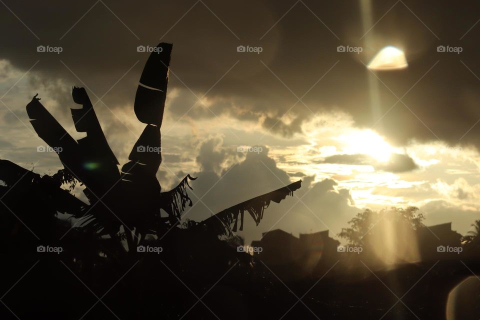 Beautiful sunset at countryside with shining sun and dark clouds before rain