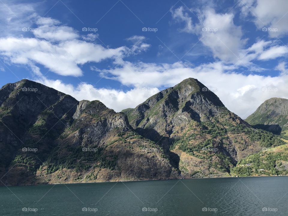 Mountains in Norway towering above the fjords. Beautiful day in flam. Picturesque 