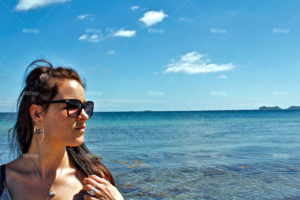 Woman wearing sunglasses standing at sea side