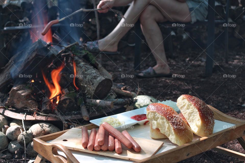 Enjoying an outdoor summer dinner roasting hotdogs over the fire.