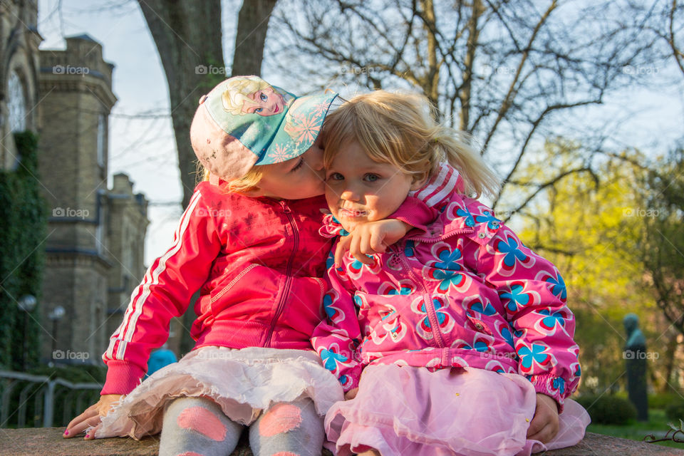 Portrait of a little girl kissing her friend