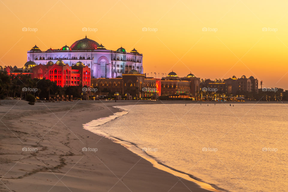 Colorful sunset in Abu Dhabi with illuminated building