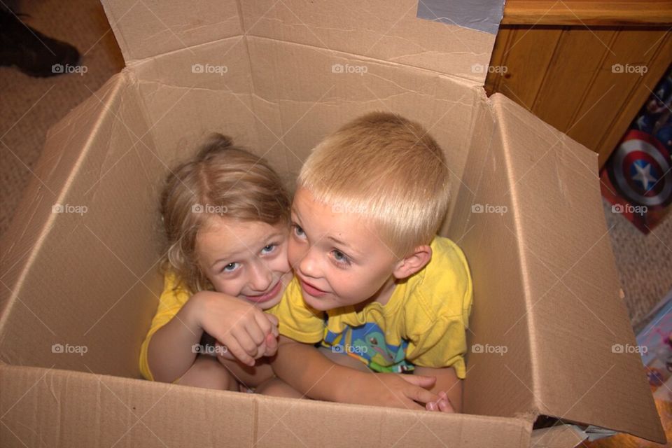 Brother and sister inside cardboard box