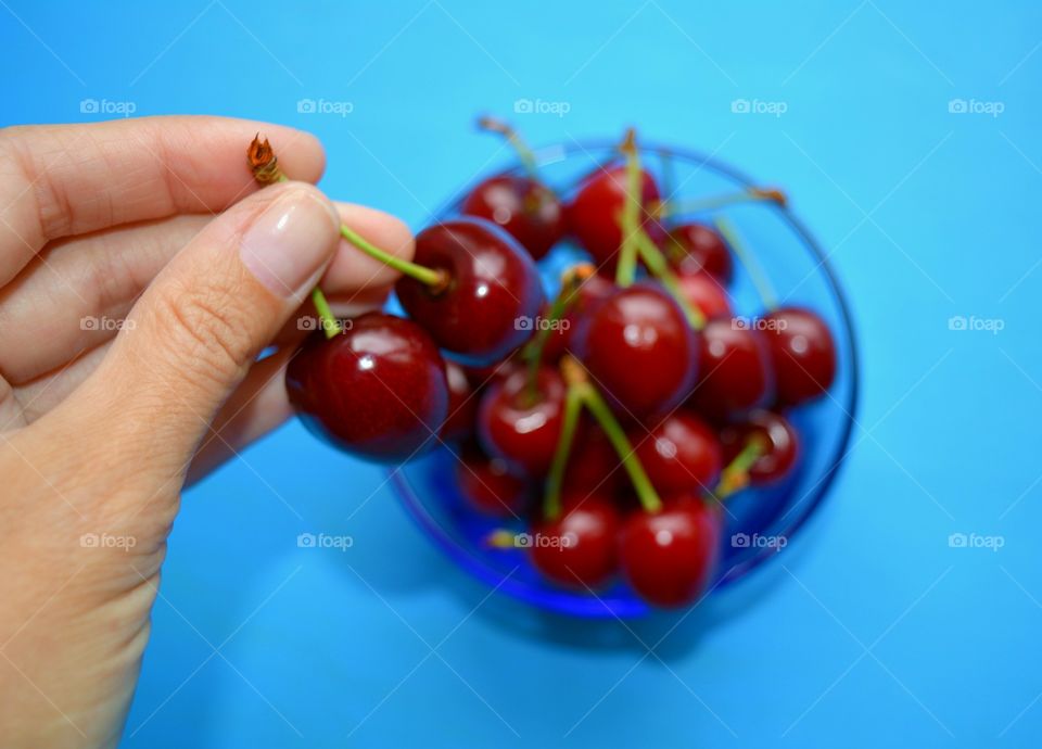 Close-up of human hand holding cherry