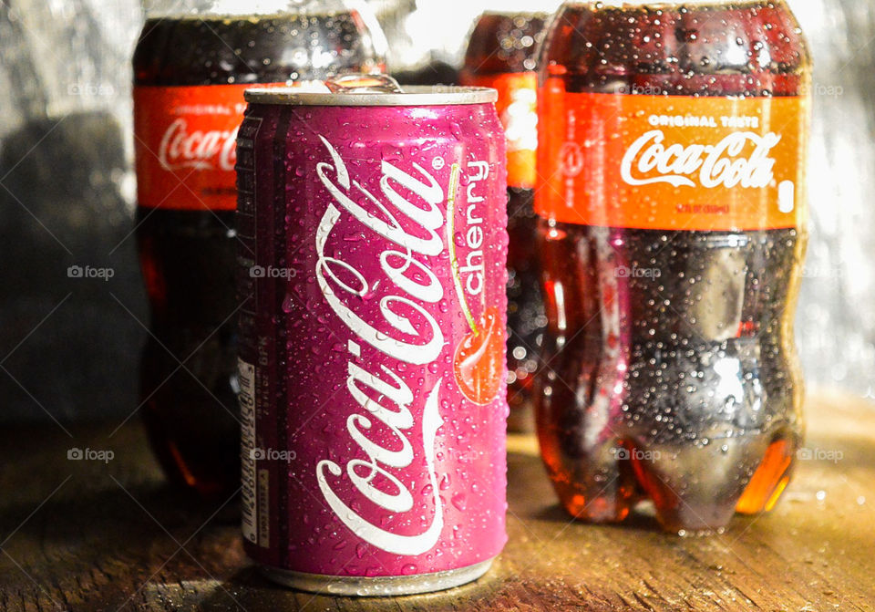 Coca-Cola and a cherry Coca-Cola only rustic table top with condensation drops
