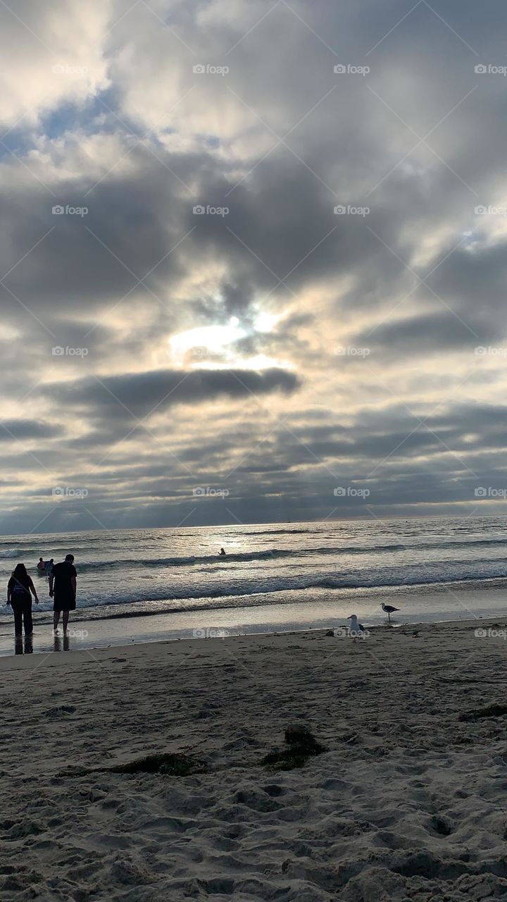Vacation days in San Diego, California. After spending entire day at the beach, kids still haven’t had enough beach time. Evening kicking in on a warm Summer day. 