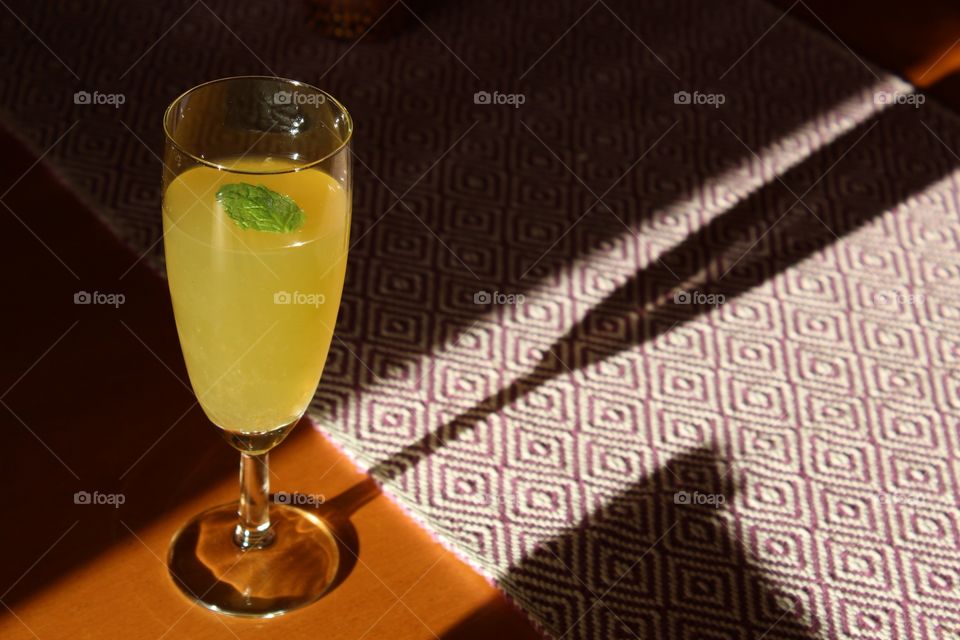 Yellow drink on a table, shadow and light