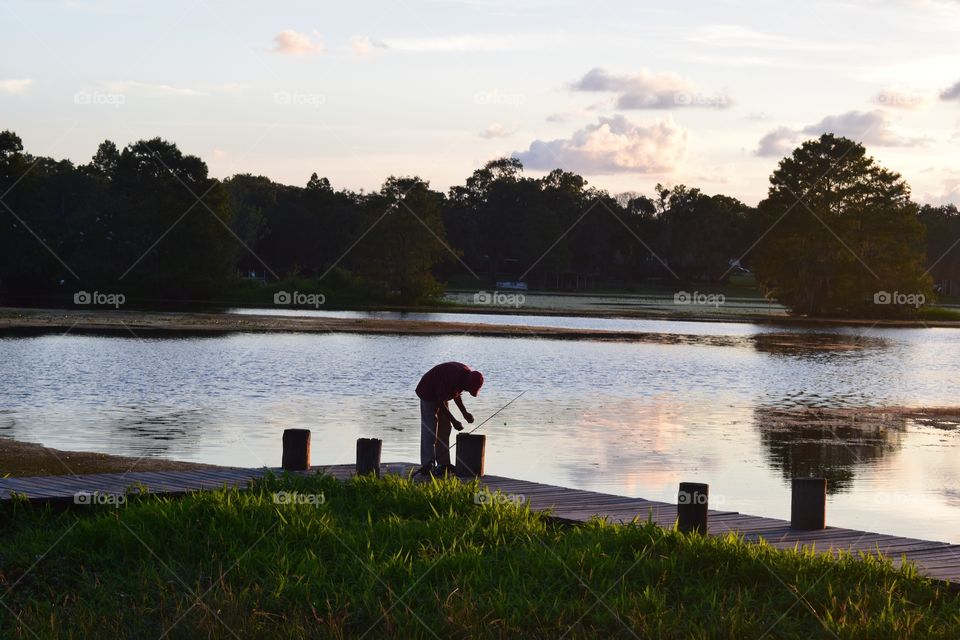 Man prepares to go fishing at a nearby lake.