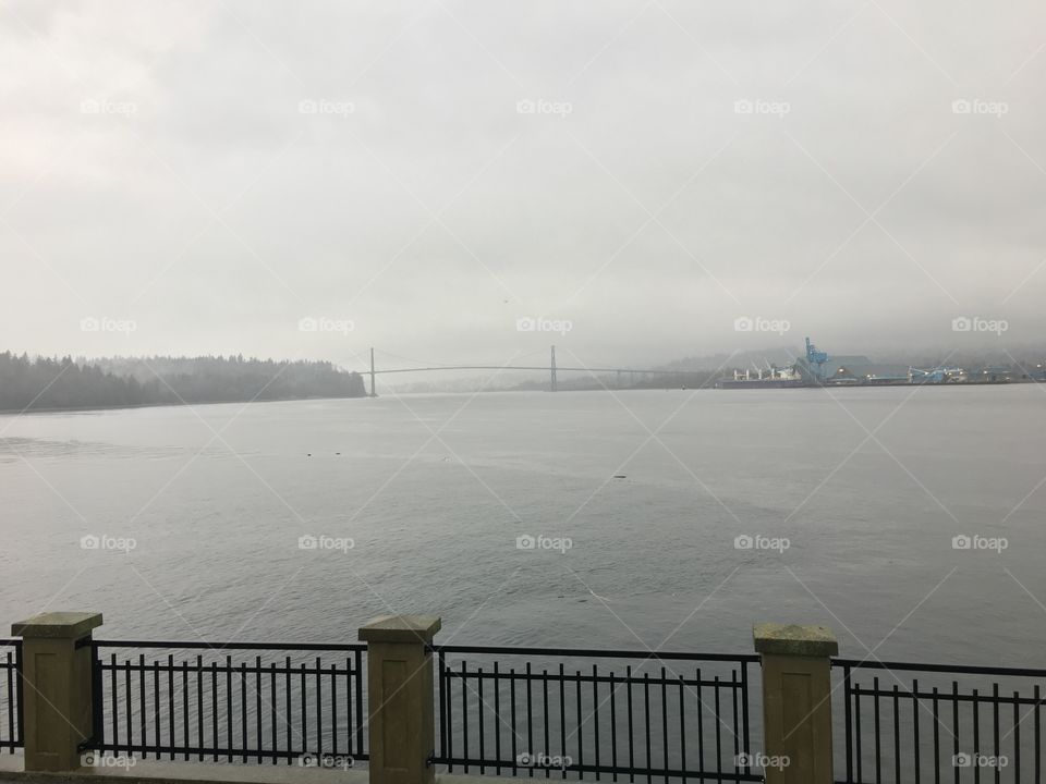 Grey ocean and bridge on a distance