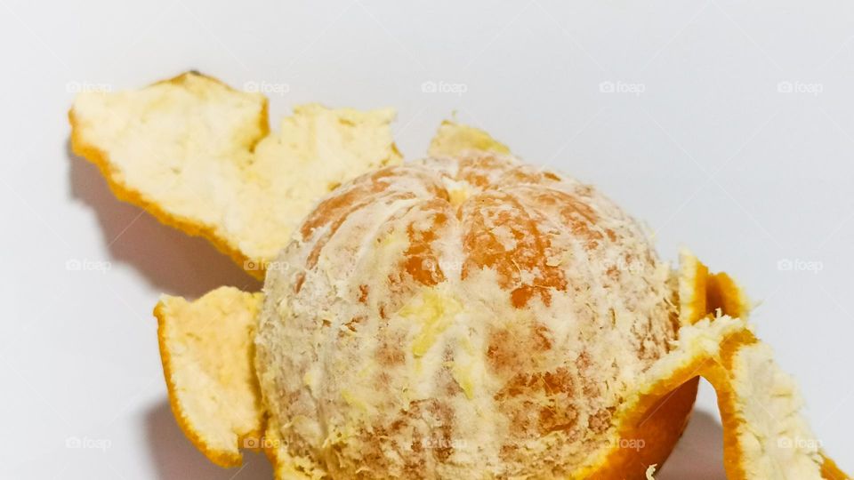 Whole orange peeled fruit on white background isolated in eye level view