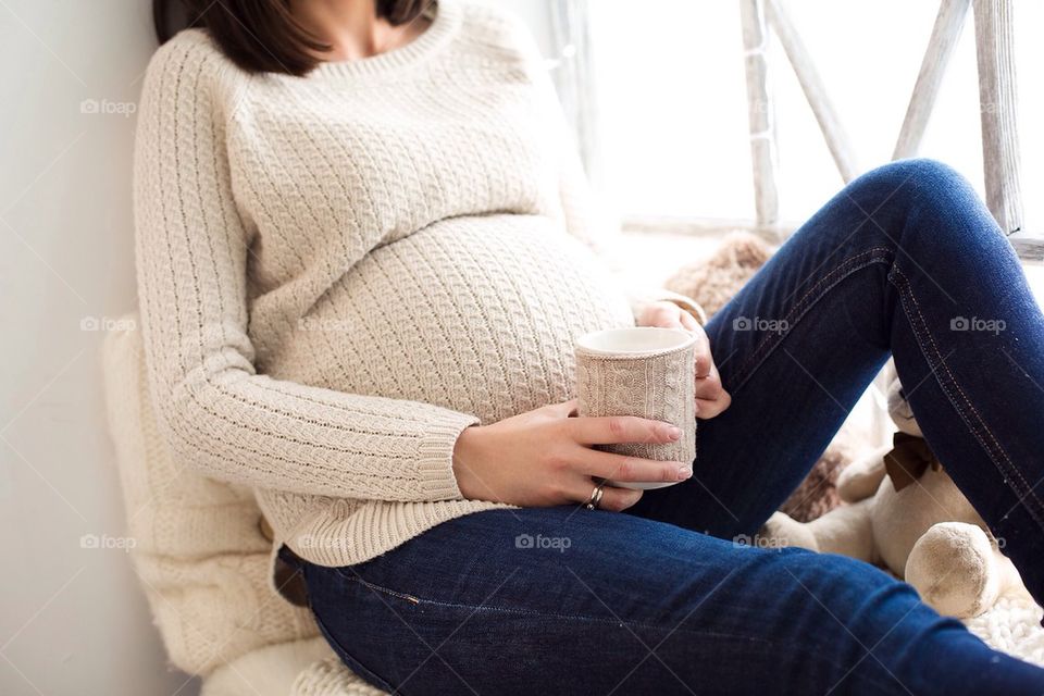 Pregnant woman holding coffee mug