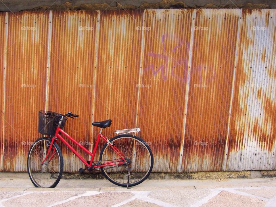 Bicycle against a rusty wall
