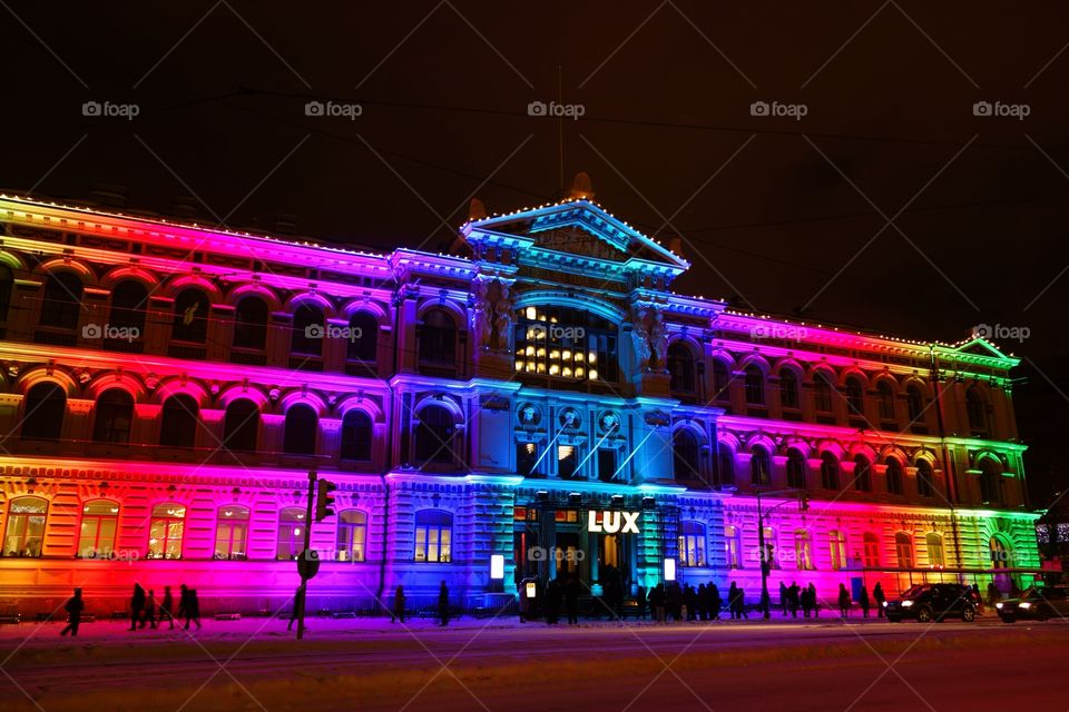 People watching Candy House light art installation by Sun Effects collective displayed on the exterior of Ateneum Art Museum at the Lux Helsinki light arts festival on 10 January 2016.