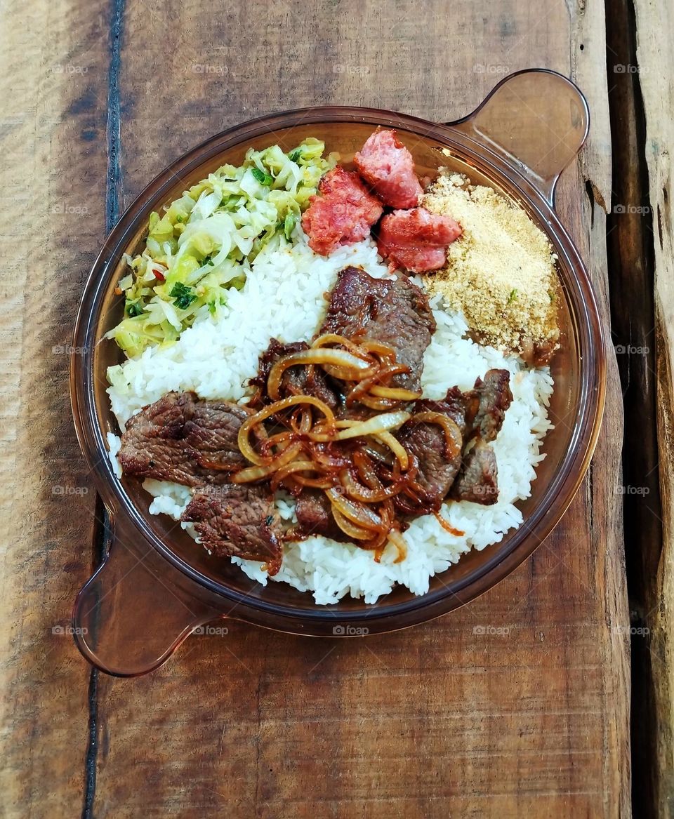 Prato típico brasileiro com arroz, feijão e farinha, bife com cebola, linguiça frita e legumes refogados... Que delícia!