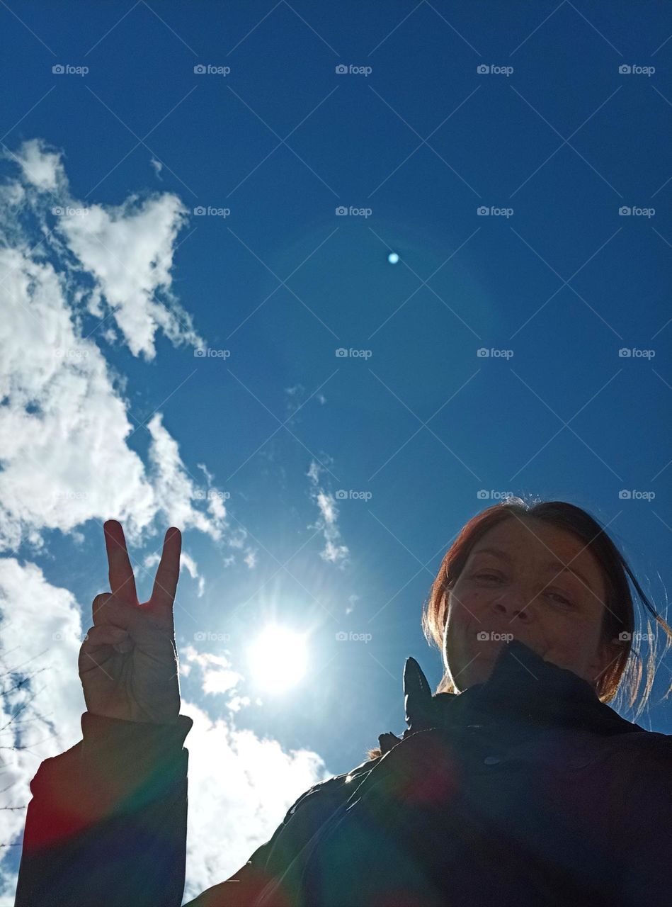 selfie woman view from the ground, blue sky background