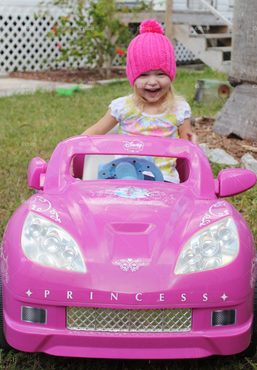 Little girl playing with her princess car