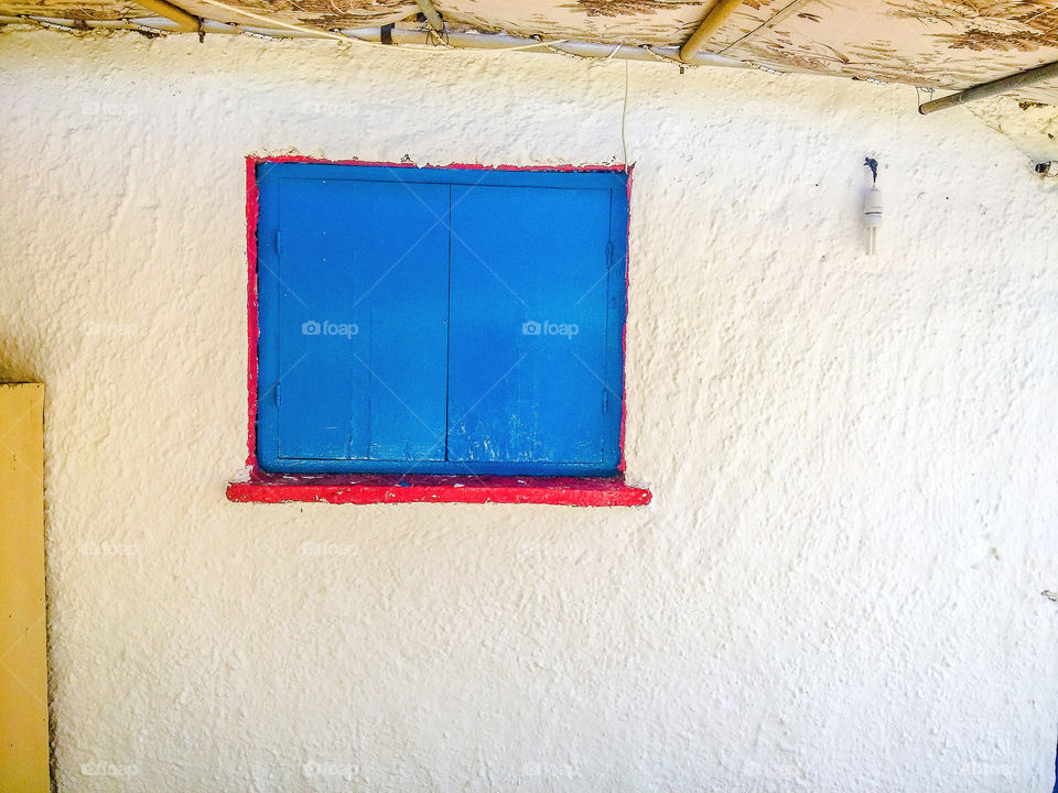 Blue painted window on white wall