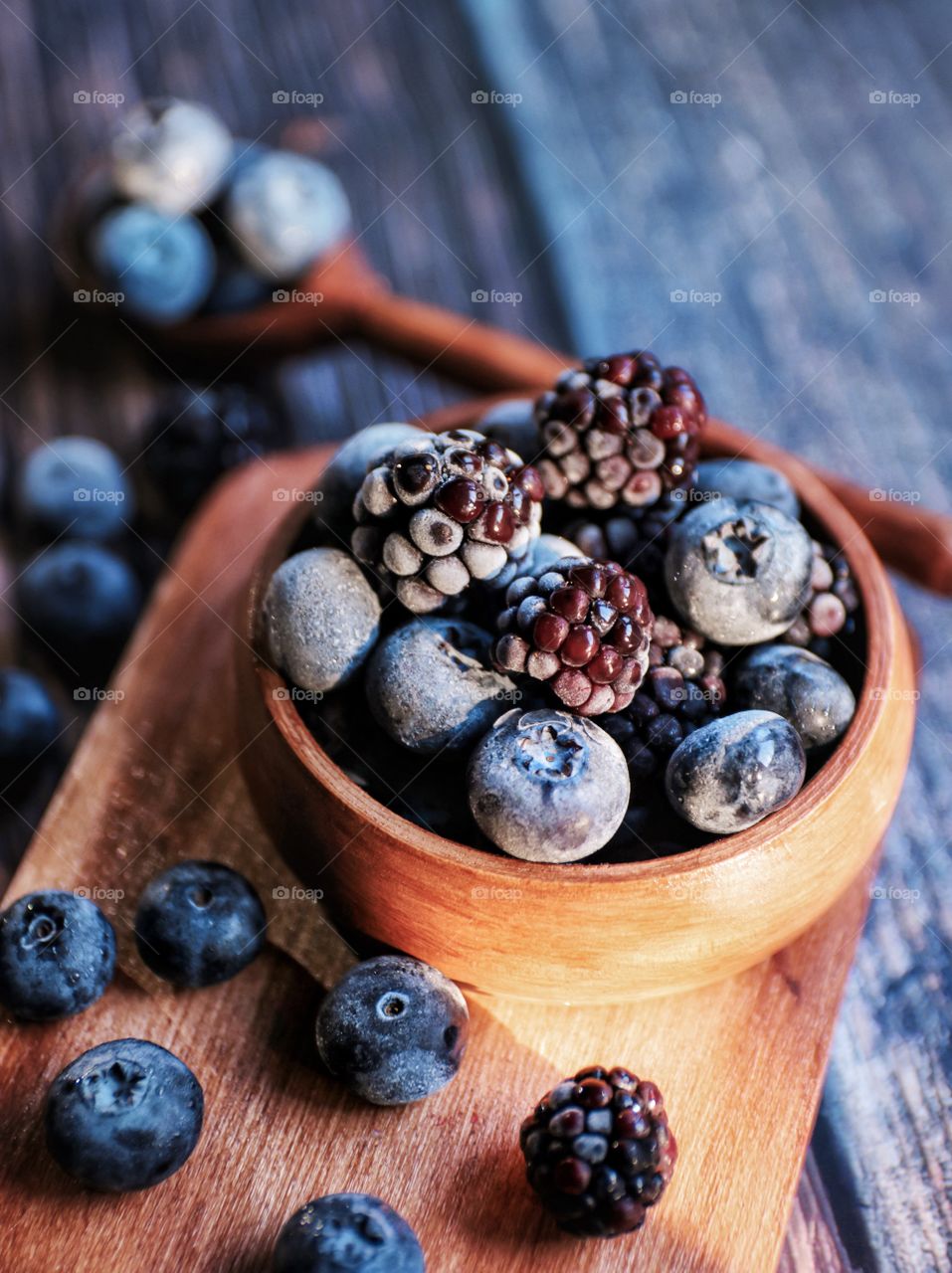 Blueberries and blackberries in wooden bowl 