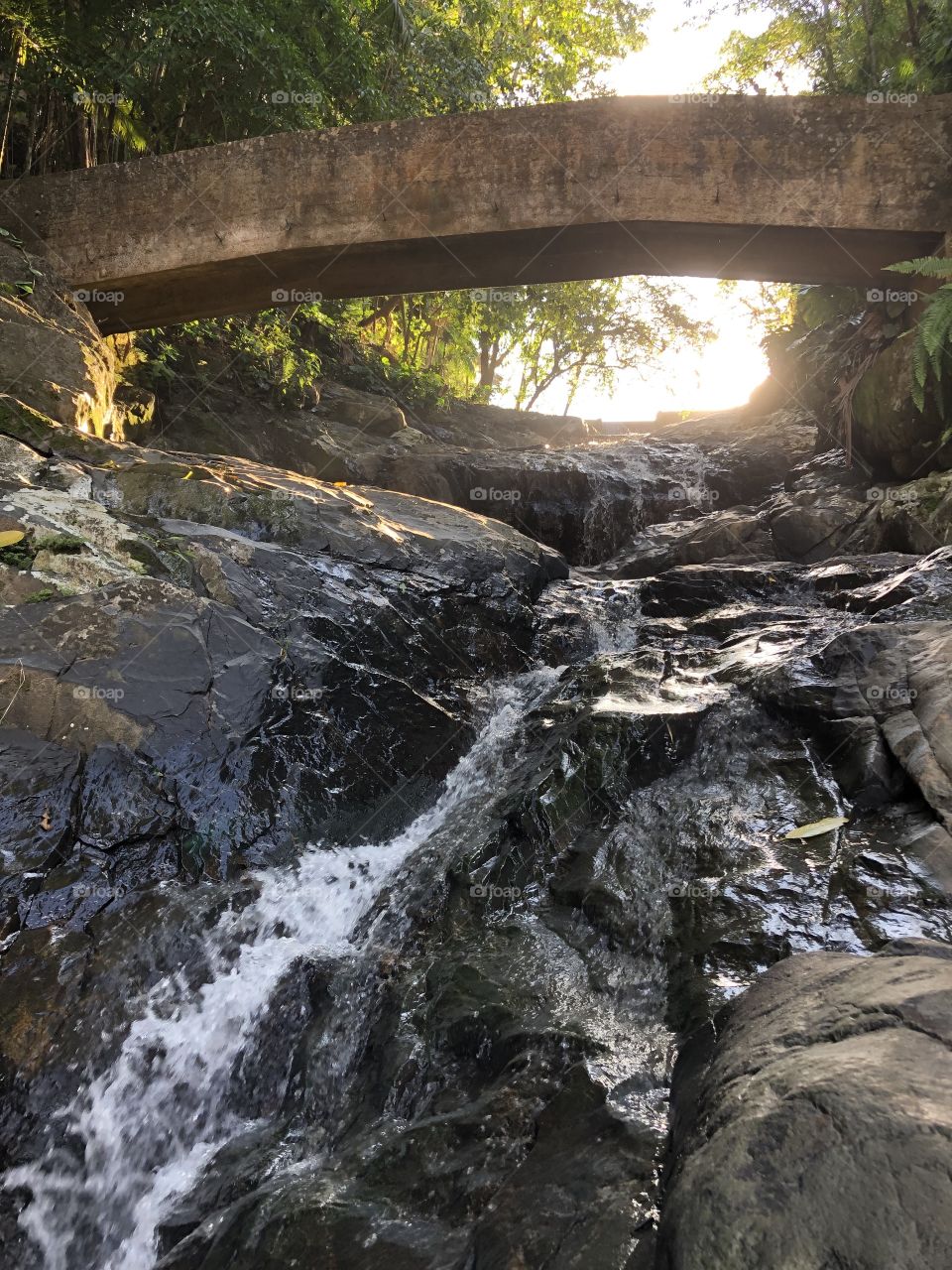 Cachoeira e ponte com sol