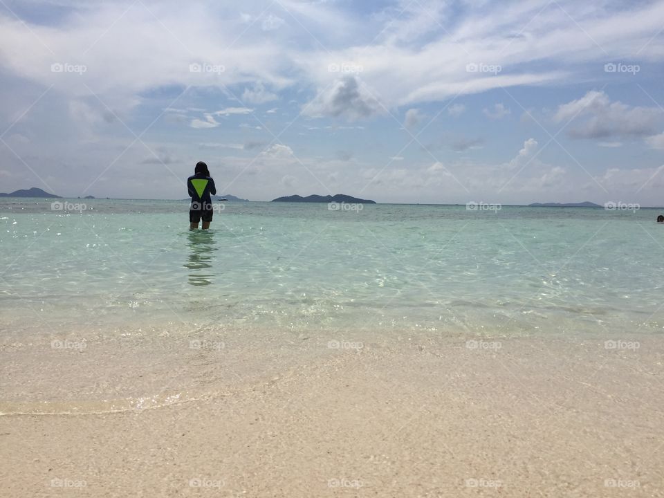 One person standing in water at the beach