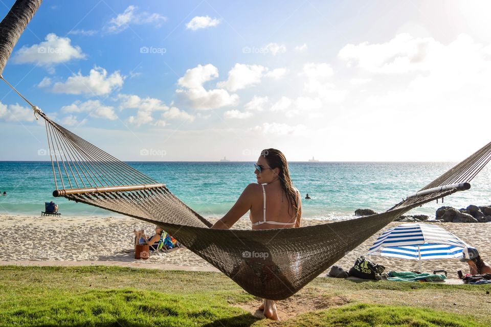 Girl in hammock facing the beach 