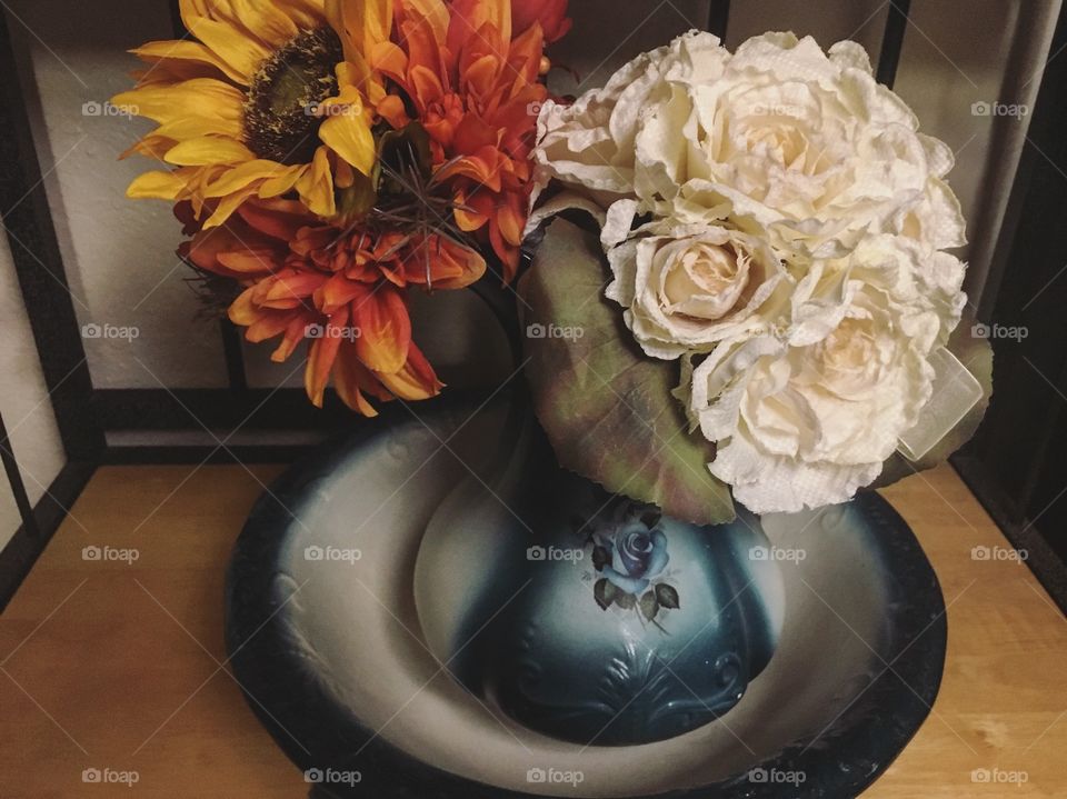 Old basin with flowers coming out of it 