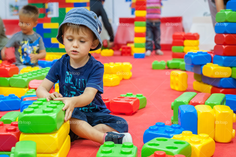 Little boy playing with big blocks.