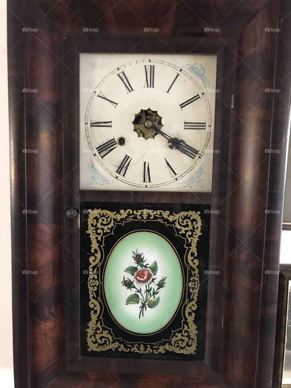 A lovely old antique clock on show at a show cottage  in Clovelly, the ornamental feature,adds to its beauty.