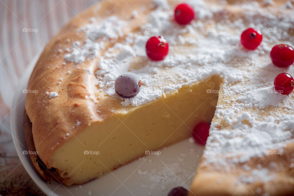 Cheesecake with cranberries and sugar on wooden background