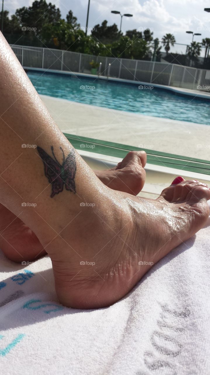 Tattoo by the pool. Soaking up the Florida sunshine by the pool.  Cute butterfly tattoo on the ankle and nice pedicure