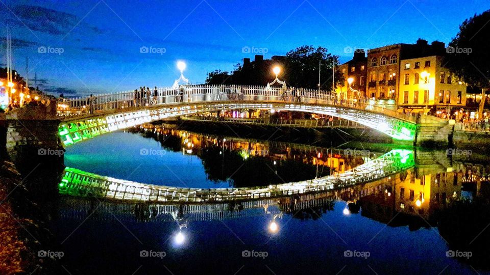 Ha'penny Bridge Dublin beautifully lit at night and reflection on water