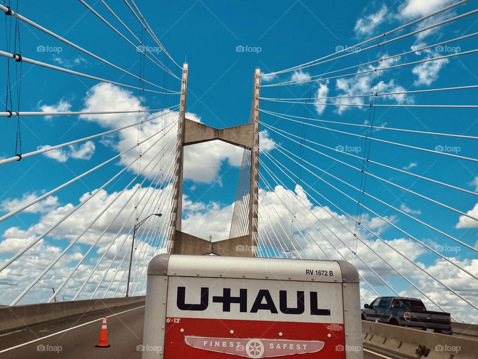 U-Haul trailer on a bridge on a sunny day.