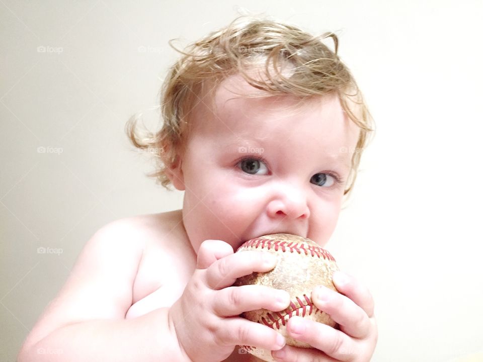 Baby holding season ball