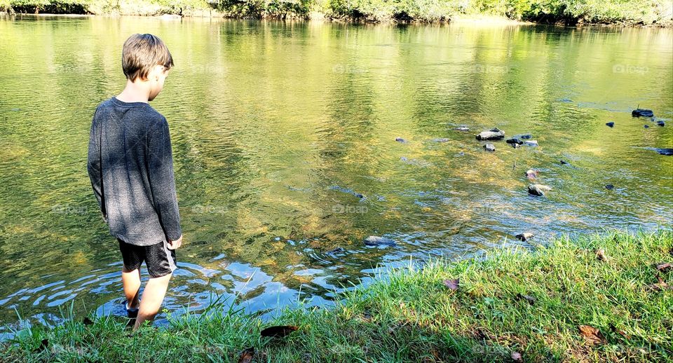 little boy wading in a stream...