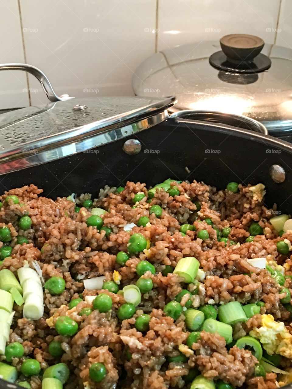 Chinese fried rice in cooking pan atop stove