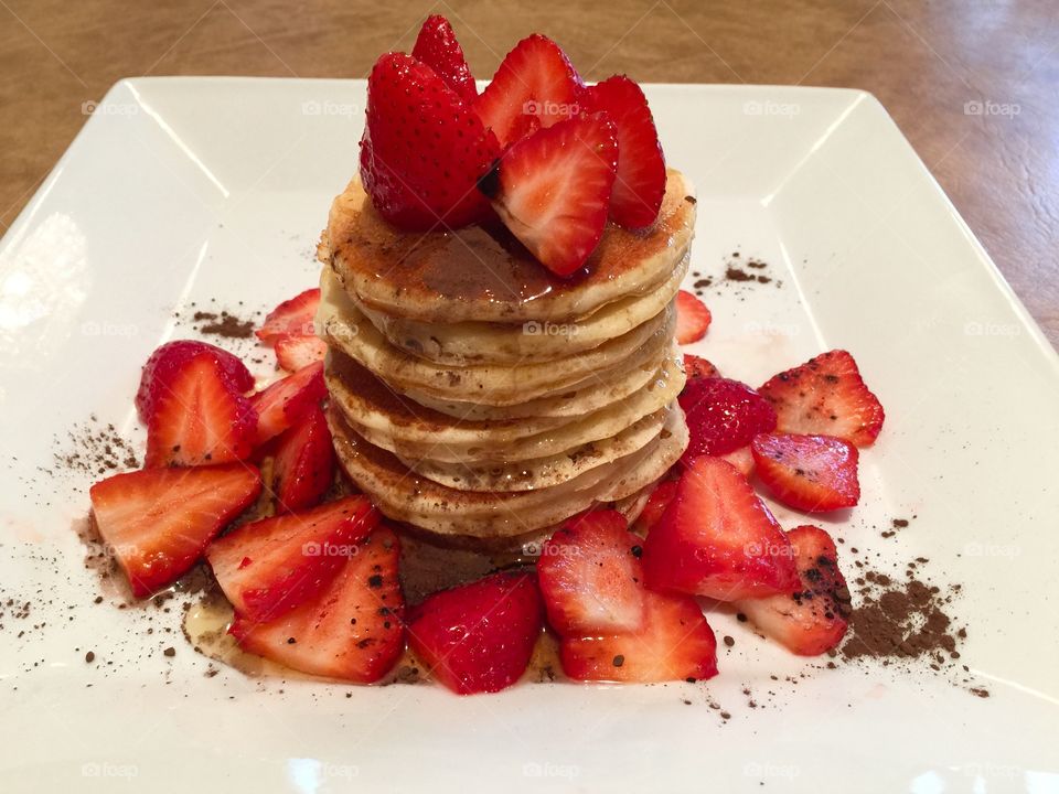 Multigrain Almond Flaxseed with coconut flake pancakes drizzled with dark organic maple syrup sprinkled with dark organic coco powder & strawberries 