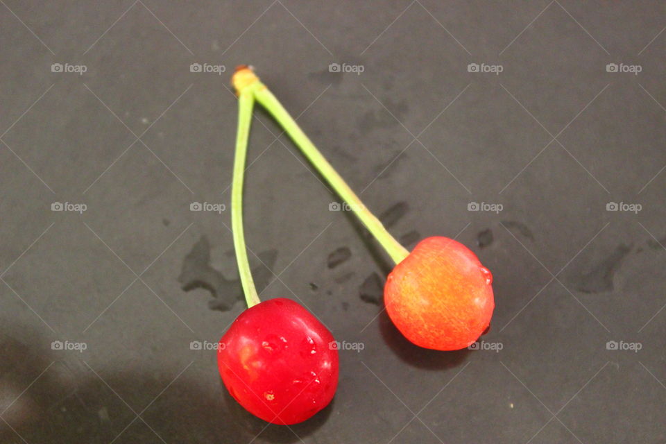 two cherries with drops of water on the table