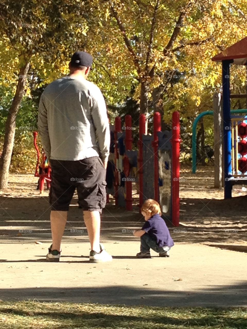 Father and son at the park in the fall. 