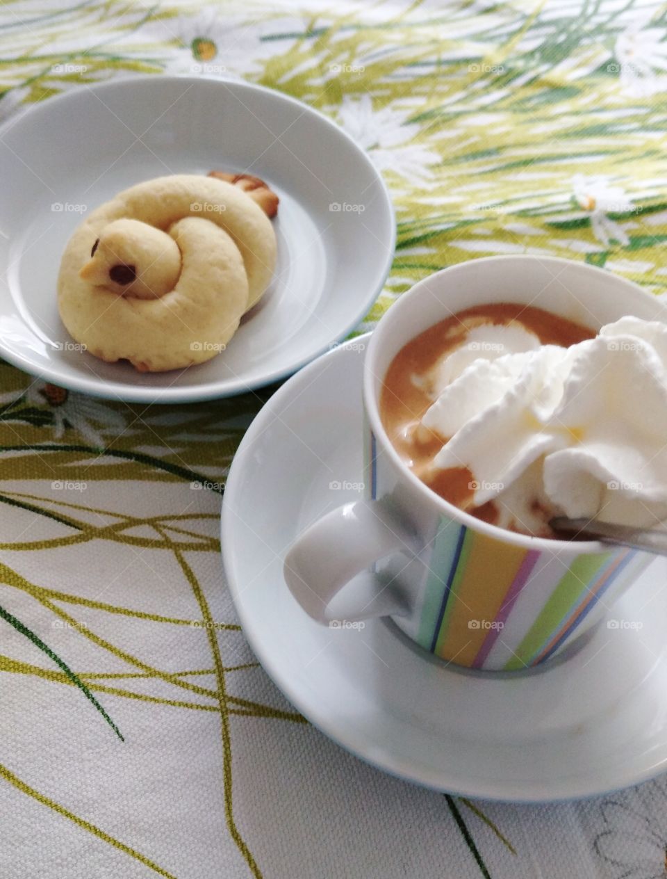 Coffee with cream and canary-shaped biscuit