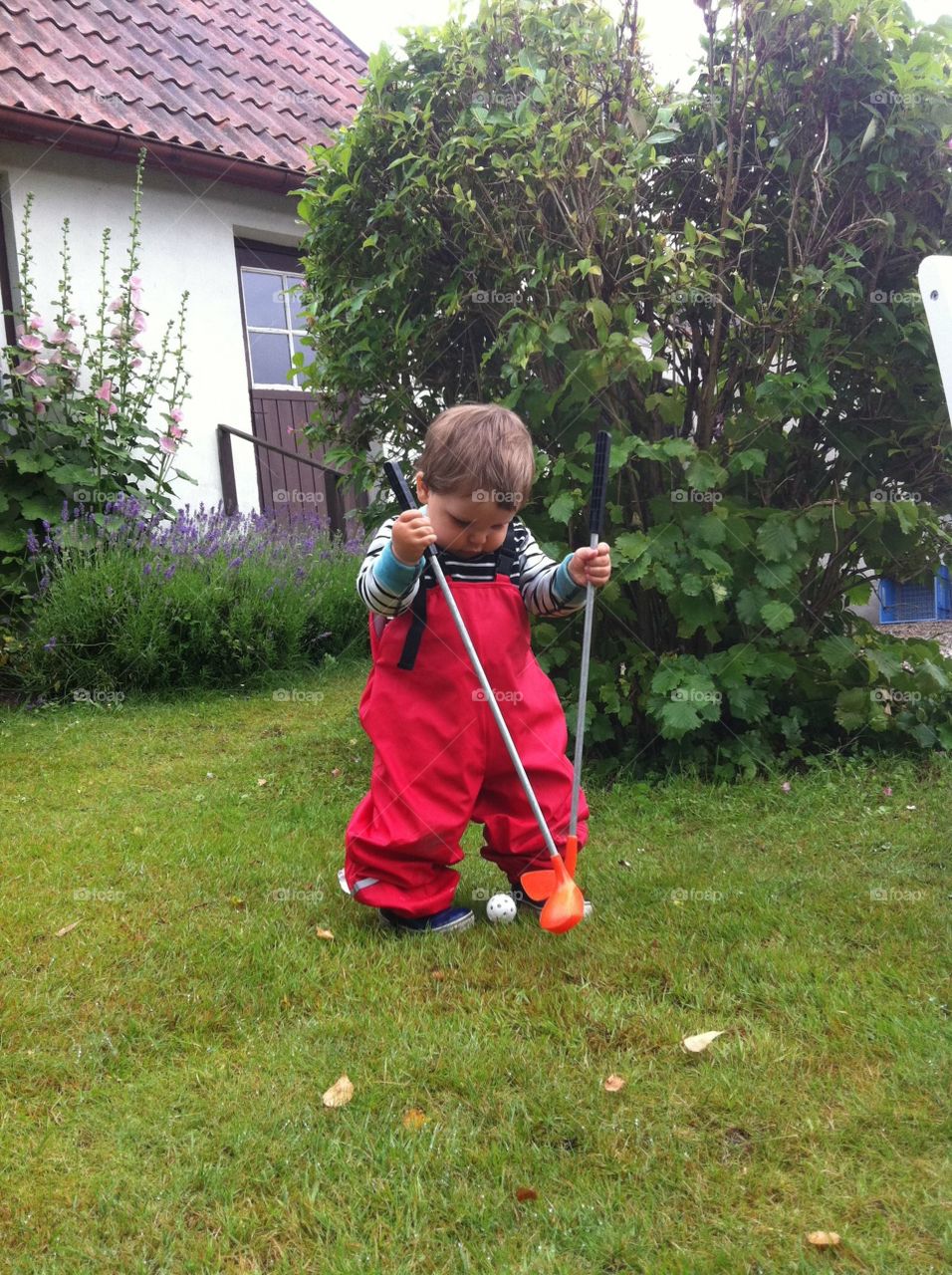 Kid practicing golf in backyard 