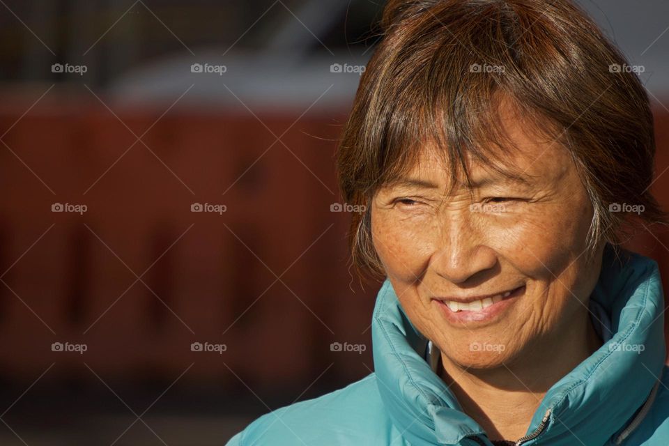 An outdoor closeup face of a smiling mature Asian woman